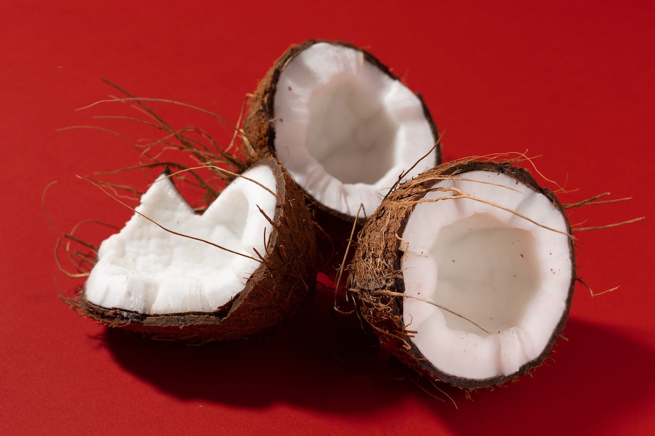 Broken open coconuts on a red background